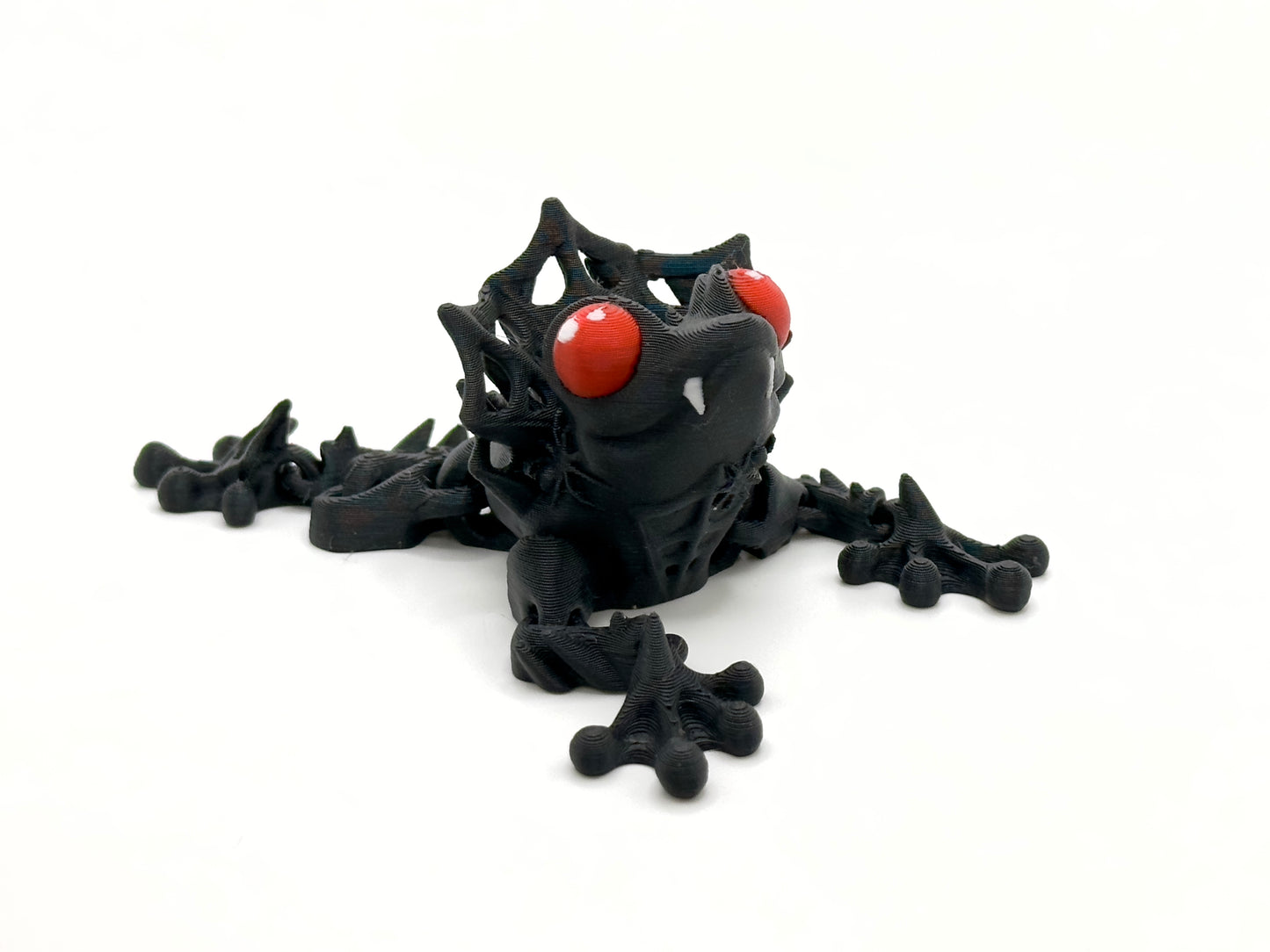 Count Frogula black with red eyes front. Count Frogula is a frog with the teeth and "collar" of a vampire