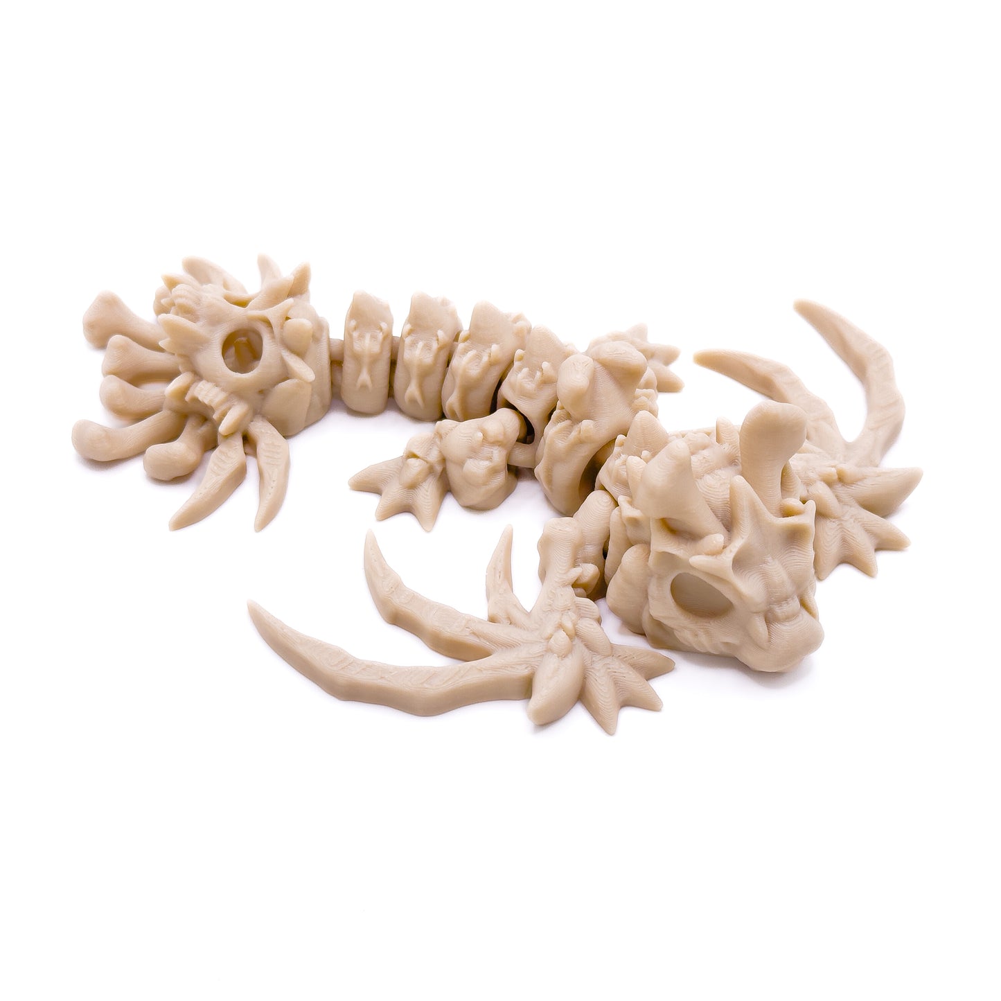 A bone-colored skeletal wyvern figure with detailed bones and claws, laying on a white surface, facing sideways.