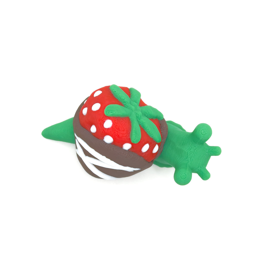 Top-down view of a green snail with a chocolate-dipped strawberry shell, featuring white dots and a green leafy top.