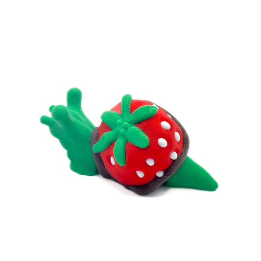 Side view of a green snail with a strawberry shell covered in chocolate, adorned with white dots and a leafy green top.