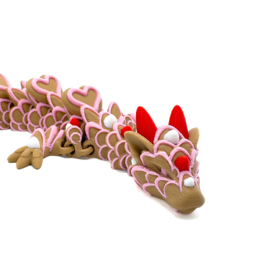 Close-up of the dragon’s head, showing red horns and detailed pink and white icing-like patterns on a brown body.