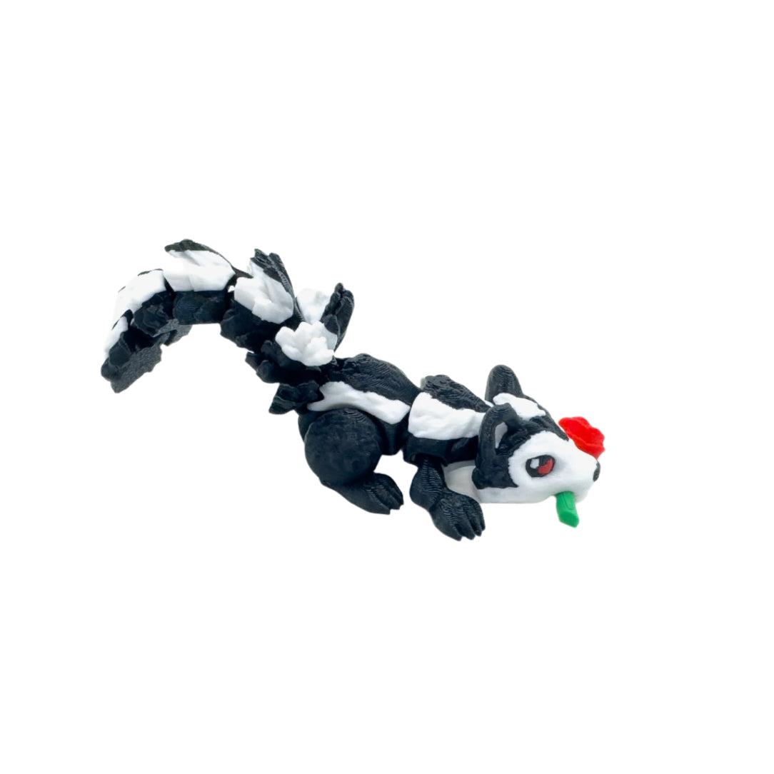 Side view of a black-and-white skunk figure lying down with a red rose in its mouth, tail raised, on a white background.