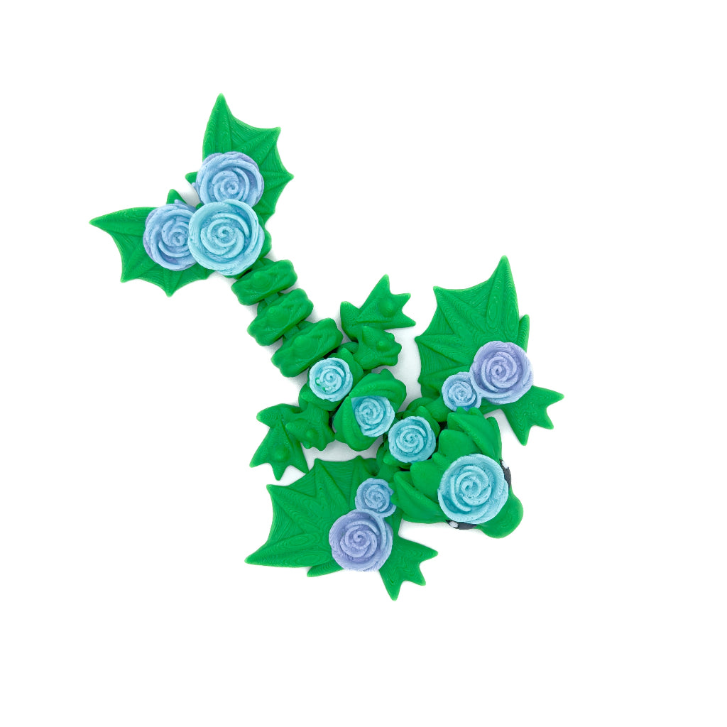 Top-down view of a green wyvern with a floral design, showing blue and purple roses and detailed leaf accents along its body.