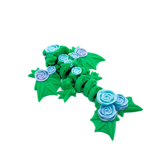 Side view of a green wyvern featuring intricate leaf-shaped wings and blue and purple roses decorating its body and tail.