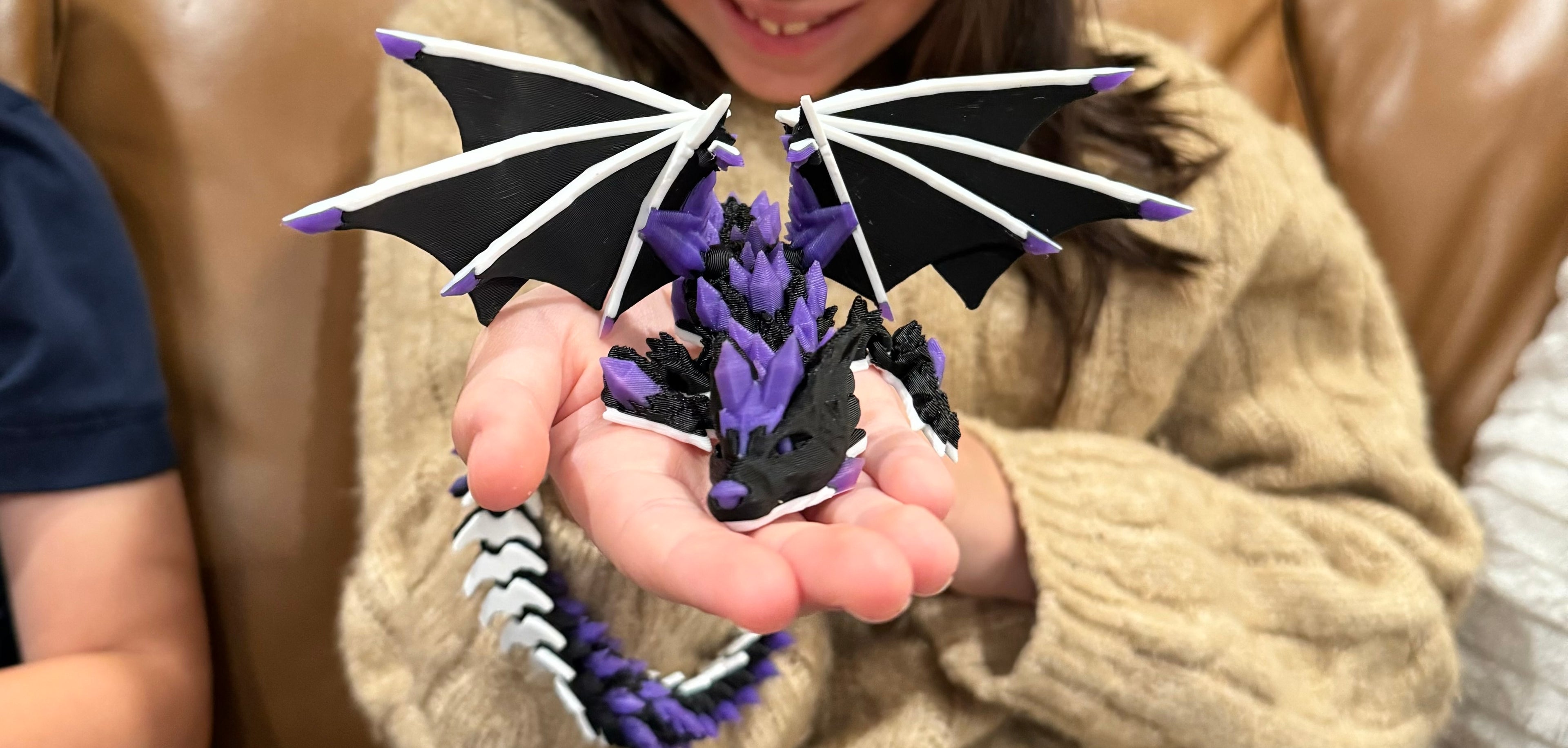 Black 3D-Printed Crystal Wolf Dragon being held by Child